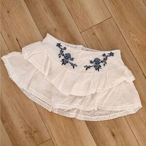 Altered state.  White Ruffled Skirt with Blue Floral Embroidery